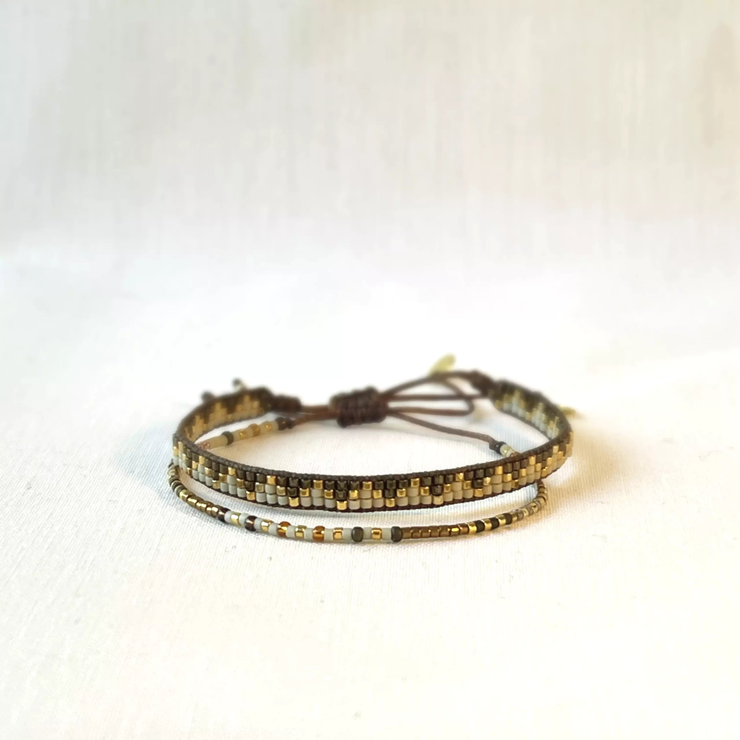 LeJu London / Sæt med to armbånd - vævet med perler i guld, brun og hvid