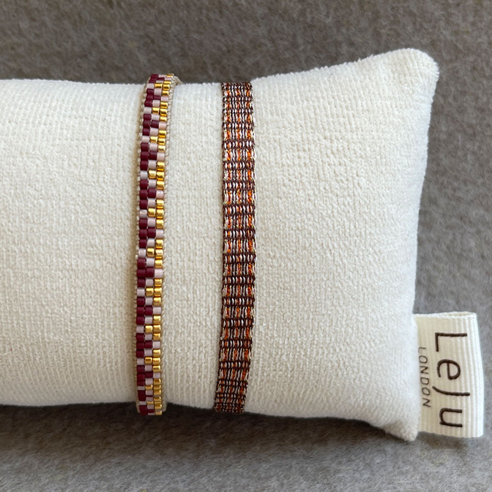 LeJu London / Sæt med to armbånd - vævet i gyldne nuancer med perler i bordeaux, rosa og guld